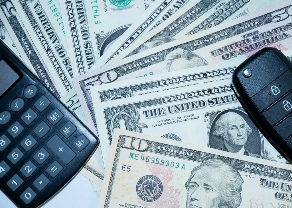 Calculator, U.S. dollar bills, and car keys arranged on a table, representing financial planning with a Personal Loan Payoff Calculator, comparing Personal Loans with Low Interest, and evaluating Personal Loans Emergency options while reviewing Good Personal Loans and Personal Loans Interest Rates.