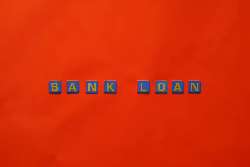 Blue letter blocks spelling “BANK LOAN” on a bright red background, representing Personal Loans Banks, comparing Lenders Personal Loans, finding Personal Loans With Low Interest, exploring Personal Loans Unsecured options, and seeking Personal Loans Cheap Interest financing.