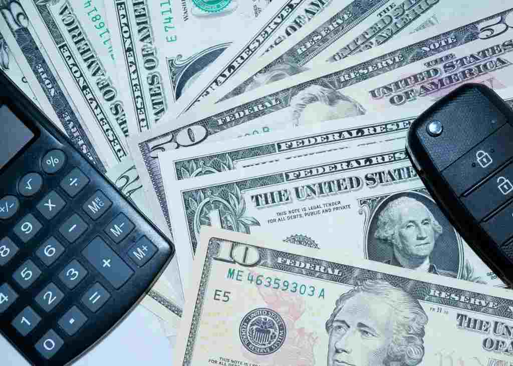 Calculator, cash, and car keys representing a personal loan used for debt consolidation, emergency expenses, transportation costs, home improvements, and everyday financial needs.